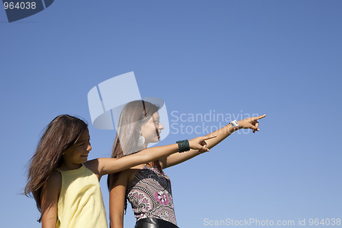 Image of Happy sisters pointing away