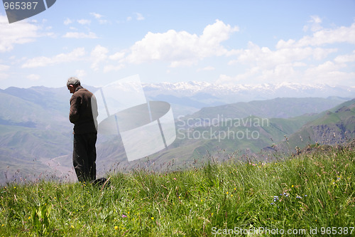 Image of Praying senior in mountains