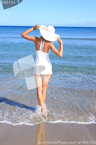 Image of Young woman standing on a beach 