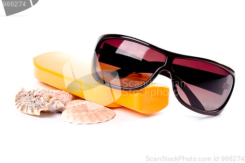 Image of sunglasses, shells and lotion 