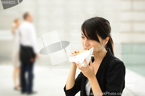 Image of young business woman have sandwich for lunch
