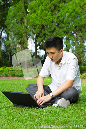 Image of man using computer outdoor