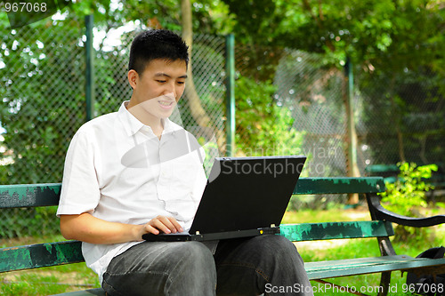 Image of man using computer outdoor
