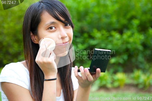 Image of woman doing makeup