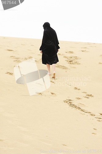 Image of Woman walking up sand hill