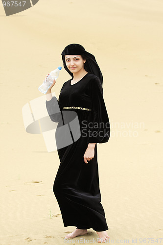 Image of Smiling barefoot woman with water bottle