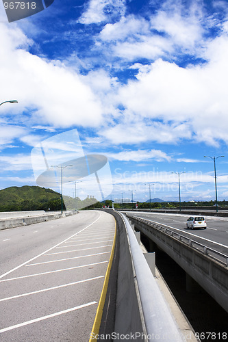 Image of road through the bridge with blue sky background of a city. 