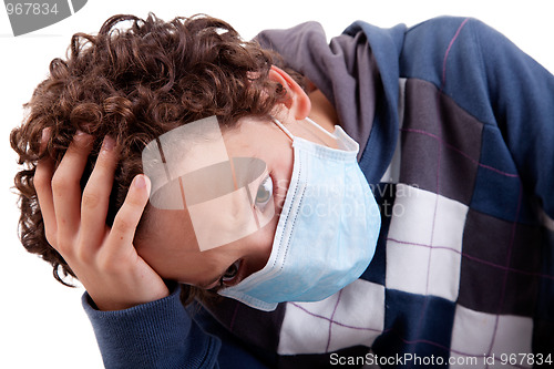 Image of young boy with a medical mask, and the hand on head