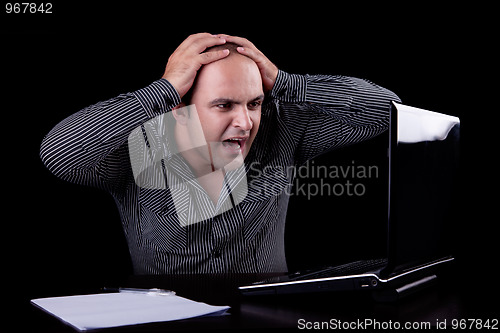 Image of businessman  surprised looking to computer