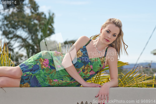 Image of pretty young woman laying on wall