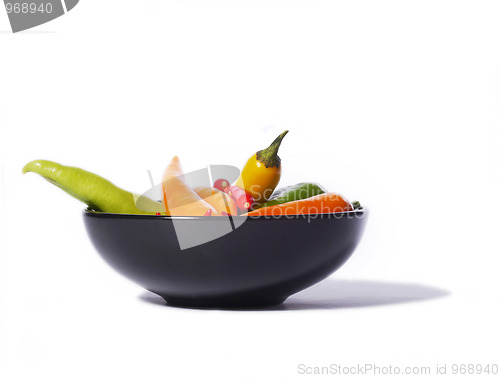 Image of Chili peppers in a black bowl, isolated on white
