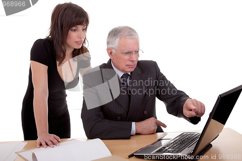 Image of businessman and woman discussing, because of work, pointing to computer