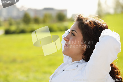 Image of Young woman with hands behing head