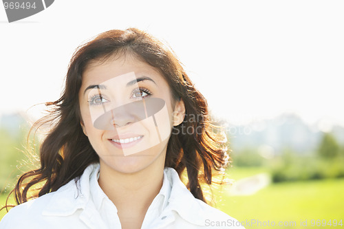 Image of Young smiling brunette looking up
