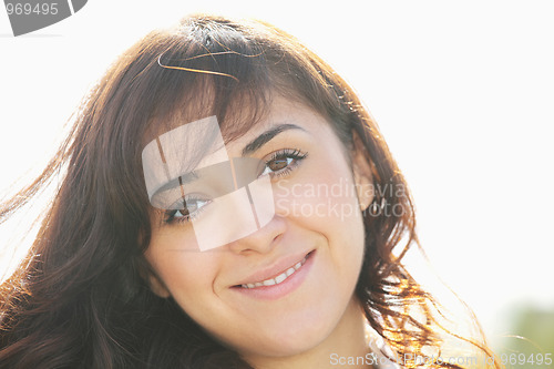 Image of Young smiling brunette in sunlight
