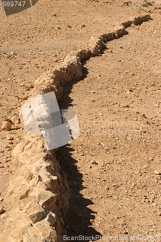 Image of Curved wall of ancient fortress ruin in the desert