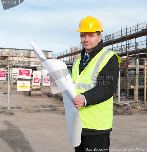 Image of Architect on building site looks at camera