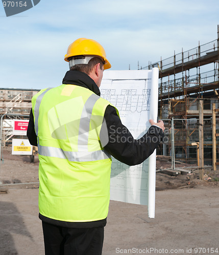 Image of Rear view of architect looking down at plans