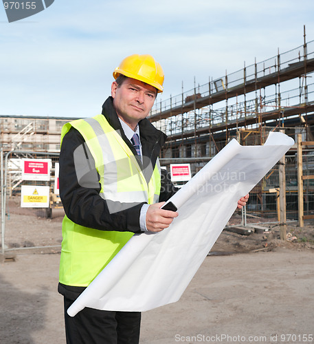 Image of Architect on building site looks at camera