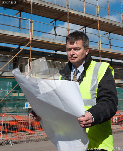 Image of Architect looks down at plans