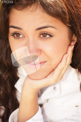 Image of Young pensive brunette leaning on hand