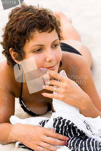 Image of brunet woman lying on a sand