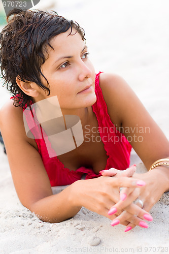 Image of woman in red lying on a sand