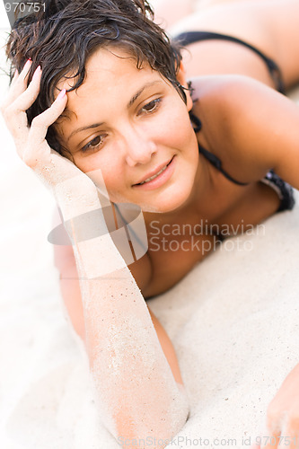 Image of brunet woman lying on a sand