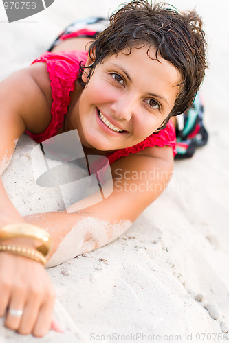 Image of woman in red lying on a sand