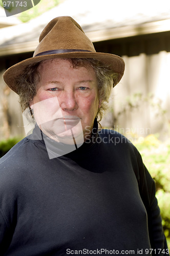 Image of middle age senior man with fashionable hat in yard