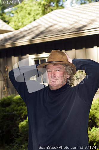 Image of middle age senior man with fashionable hat in yard