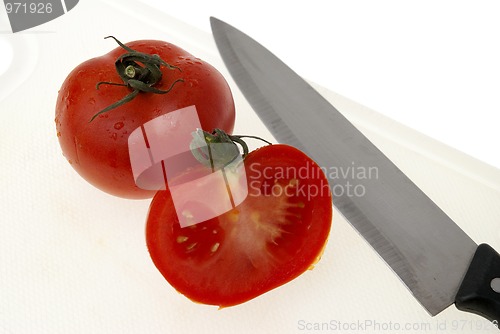 Image of Cutting white plastic board with a knife and tomato