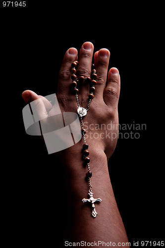 Image of hands of a young latin men with a crucifix
