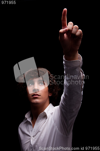 Image of young man  looking up to the light and pointing - sign of faith