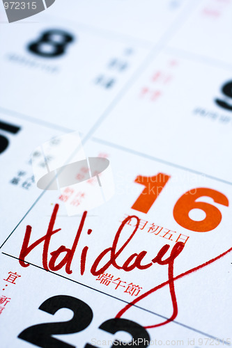 Image of Hand writing holiday important date on calendar