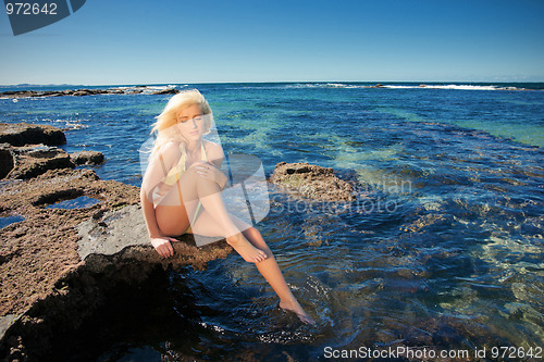 Image of young woman on reef at sea