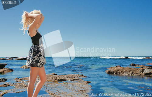 Image of young woman on reef at sea