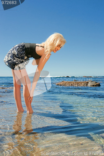 Image of young woman on reef at sea