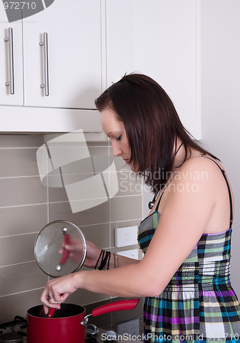Image of young woman cooking dinner