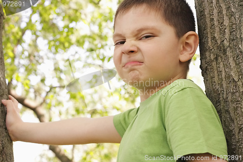 Image of Grimacing boy between trees