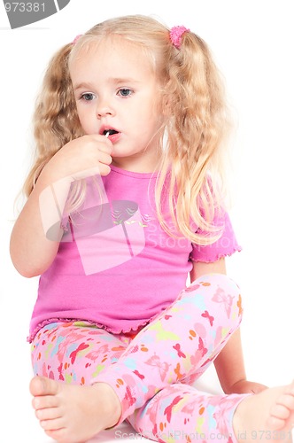 Image of Little cute girl in studio eating candy