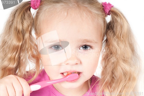 Image of Little cute girl in studio brushing teeth