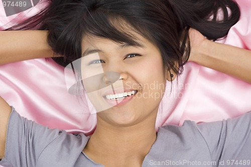 Image of beautiful woman on pink silk