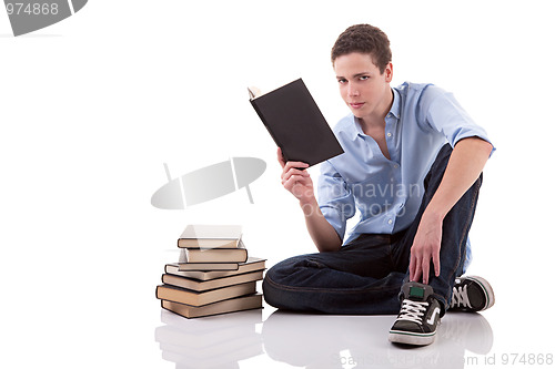 Image of cute boy reading a book on the floor