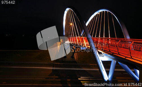 Image of Pedestrian bridge over road at night