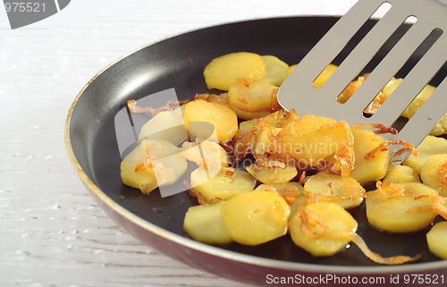 Image of Fried potatoes' slices on frying pan
