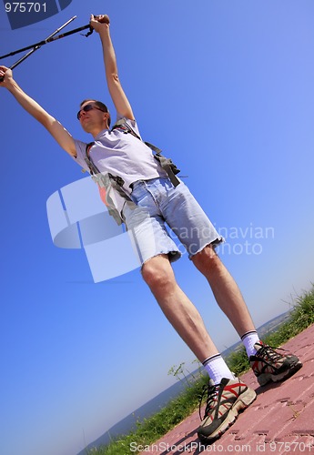 Image of Hiker with raised arms and trekking sticks