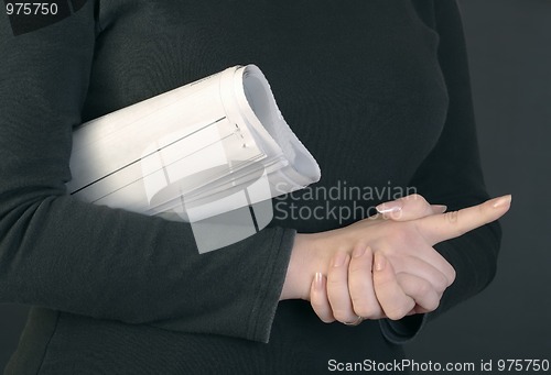 Image of Woman hands and rolled newspaper