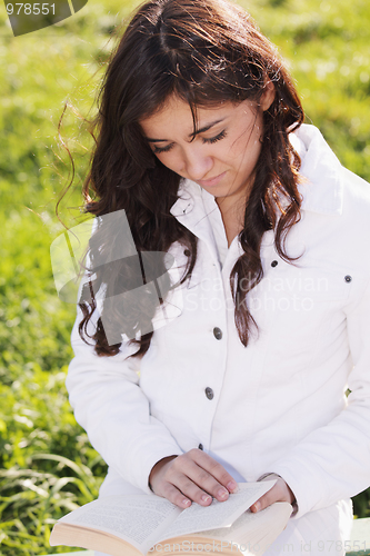 Image of Young brunette in white reading book