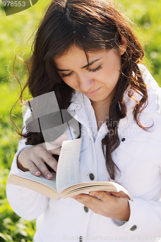 Image of Young brunette looking through book